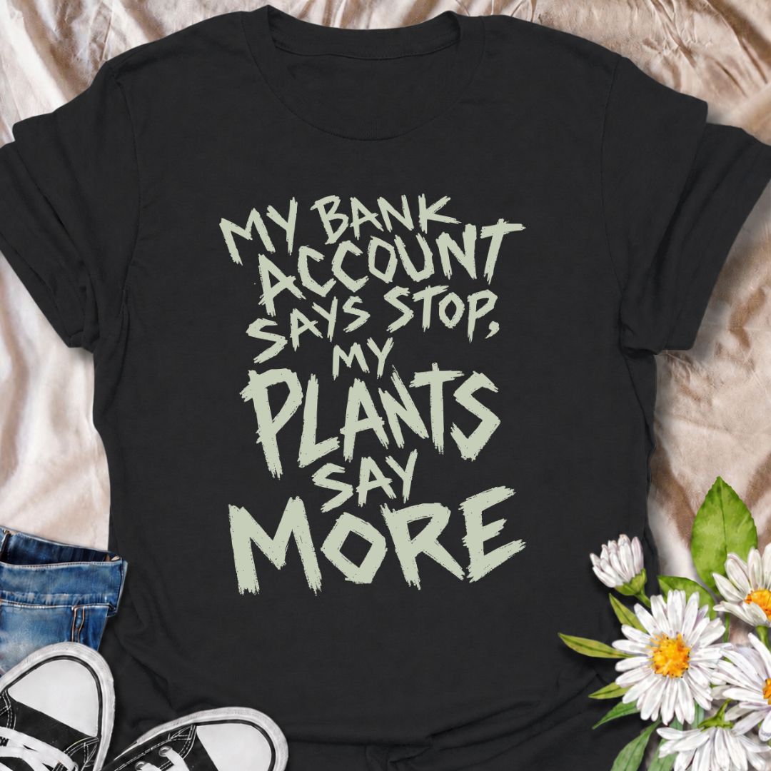 A funny plant T-shirt for anyone whose budget says stop but whose houseplant collection has other ideas. The phrase “My Bank Account Says Stop, My Plants Say More” delivers relatable plant-shopping humor for collectors who can never quite resist another plant. Its bold hand-drawn typography gives the design an expressive, slightly chaotic feel that suits the joke perfectly. It makes a great gift for plant parents, nursery regulars, and anyone whose indoor jungle keeps growing faster than their savings. Perf