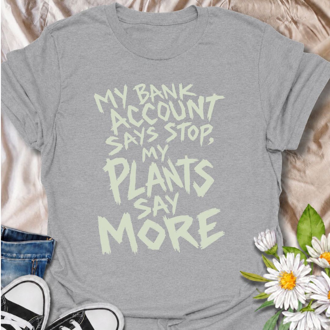 A funny plant T-shirt for anyone whose budget says stop but whose houseplant collection has other ideas. The phrase “My Bank Account Says Stop, My Plants Say More” delivers relatable plant-shopping humor for collectors who can never quite resist another plant. Its bold hand-drawn typography gives the design an expressive, slightly chaotic feel that suits the joke perfectly. It makes a great gift for plant parents, nursery regulars, and anyone whose indoor jungle keeps growing faster than their savings. Perf