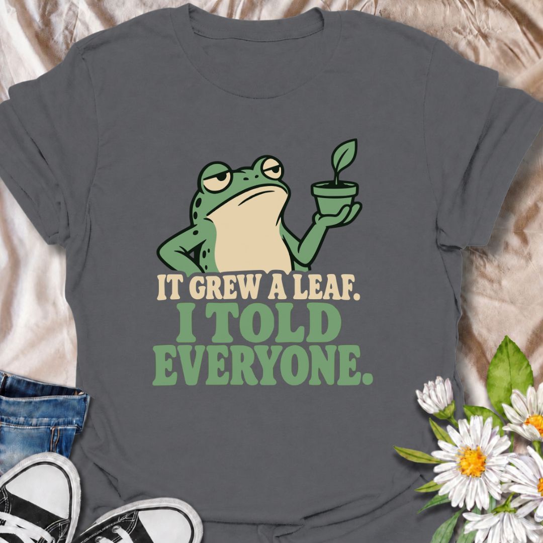 A funny plant T-shirt for anyone who celebrates every tiny bit of new growth like a major event. Featuring a deadpan frog proudly holding up a small plant, the phrase “It Grew a Leaf. I Told Everyone.” captures classic plant-parent behavior perfectly. It is ideal for houseplant lovers, indoor gardeners, propagation fans, and anyone who checks their plants for new growth far too often. The character-led design keeps the humor clear while giving it plenty of personality. A great gift for plant collectors, fro