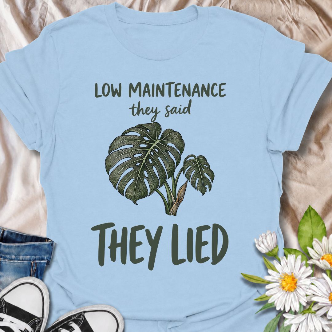 A funny plant T-shirt for anyone who was promised an easy-care houseplant and quickly discovered otherwise. The phrase “Low Maintenance, They Said. They Lied.” delivers dry, relatable humor that plant parents and monstera lovers will instantly understand. Featuring a leafy monstera illustration, the design feels simple, wearable, and clearly rooted in houseplant culture. It makes a great gift for indoor gardeners, plant collectors, and anyone who has spent far more time troubleshooting a supposedly easy pla