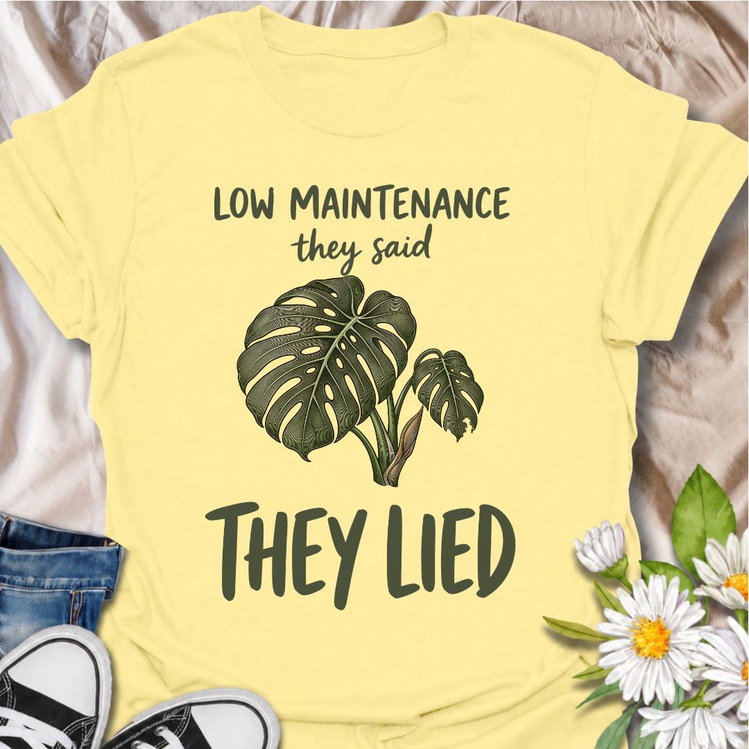 A funny plant T-shirt for anyone who was promised an easy-care houseplant and quickly discovered otherwise. The phrase “Low Maintenance, They Said. They Lied.” delivers dry, relatable humor that plant parents and monstera lovers will instantly understand. Featuring a leafy monstera illustration, the design feels simple, wearable, and clearly rooted in houseplant culture. It makes a great gift for indoor gardeners, plant collectors, and anyone who has spent far more time troubleshooting a supposedly easy pla