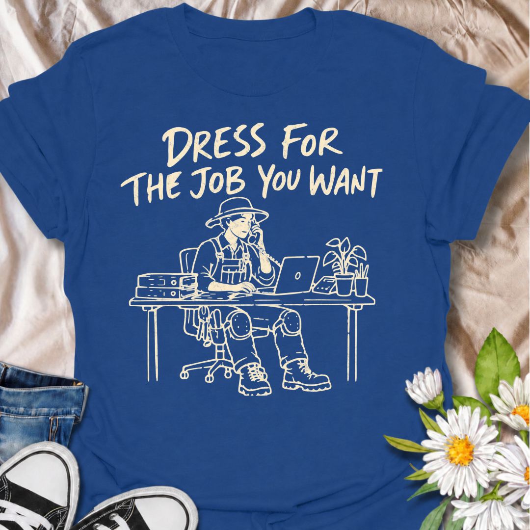 A funny gardening T-shirt for anyone who would rather be dressed for the garden than stuck behind a desk. The phrase “Dress for the Job You Want” pairs with a gardener in full work gear sitting in an office setting for a dry, absurd bit of garden humor. Featuring overalls, knee pads, work boots, tools, a laptop, and desk accessories, the design is perfect for gardeners who know exactly where they would rather be. It makes a great gift for professional gardeners, backyard growers, plant lovers, and anyone dr