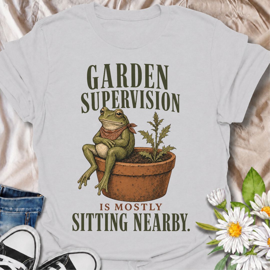 A funny gardening T-shirt for anyone who knows that supervising the garden often means sitting nearby and keeping an eye on things. The phrase “Garden Supervision Is Mostly Sitting Nearby” pairs perfectly with a deadpan frog perched beside a potted weed for dry, character-led garden humor. It is ideal for backyard gardeners, plant lovers, frog fans, and anyone who spends plenty of time simply observing what is growing. The vintage-style illustration gives the design personality while keeping it easy to wear