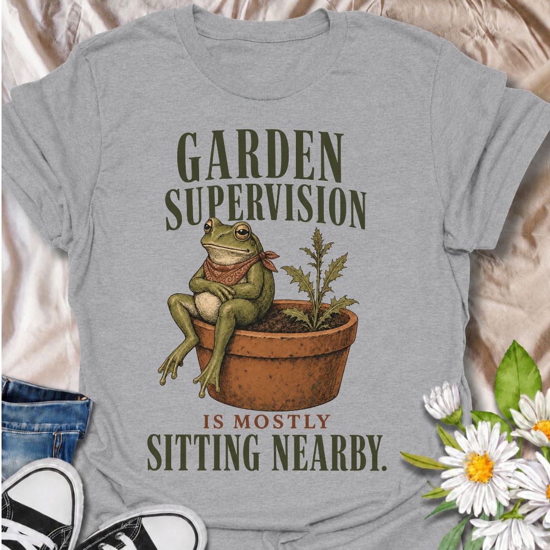 A funny gardening T-shirt for anyone who knows that supervising the garden often means sitting nearby and keeping an eye on things. The phrase “Garden Supervision Is Mostly Sitting Nearby” pairs perfectly with a deadpan frog perched beside a potted weed for dry, character-led garden humor. It is ideal for backyard gardeners, plant lovers, frog fans, and anyone who spends plenty of time simply observing what is growing. The vintage-style illustration gives the design personality while keeping it easy to wear