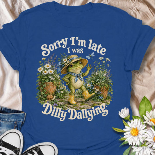 A funny gardening T-shirt for anyone who loses track of time wandering through the garden. The phrase “Sorry I’m Late, I Was Dilly Dallying” pairs with a cheerful frog strolling among flowers for a playful, character-led design. It is perfect for gardeners, flower lovers, frog fans, and anyone who would rather take the scenic route through the garden than rush anywhere. The whimsical vintage-style artwork gives it plenty of personality while keeping the humor easy to understand. A great gift for cottage gar