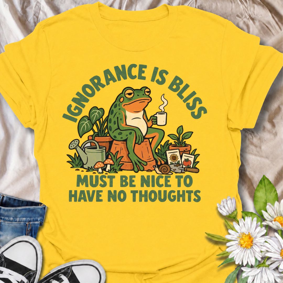 A funny gardening T-shirt for anyone who suspects life might be easier with fewer thoughts and more time around plants. The phrase “Ignorance Is Bliss — Must Be Nice to Have No Thoughts” pairs with a deadpan frog, coffee mug, potted plants, and gardening supplies for sarcastic, character-led humor. It is perfect for gardeners, plant lovers, frog fans, and anyone who enjoys a slightly dry, absurd joke. The retro illustration gives the design plenty of personality while keeping it firmly rooted in the garden