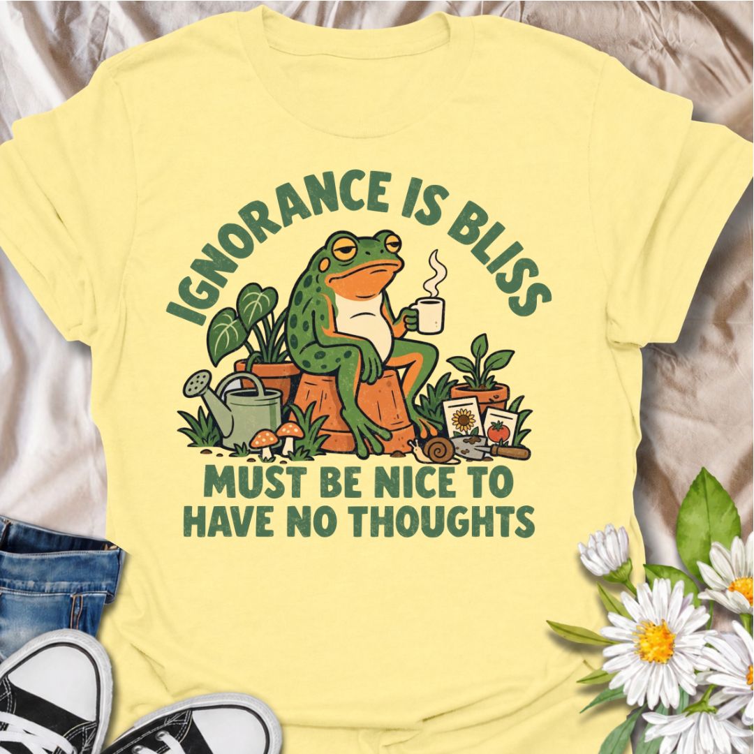A funny gardening T-shirt for anyone who suspects life might be easier with fewer thoughts and more time around plants. The phrase “Ignorance Is Bliss — Must Be Nice to Have No Thoughts” pairs with a deadpan frog, coffee mug, potted plants, and gardening supplies for sarcastic, character-led humor. It is perfect for gardeners, plant lovers, frog fans, and anyone who enjoys a slightly dry, absurd joke. The retro illustration gives the design plenty of personality while keeping it firmly rooted in the gardeni