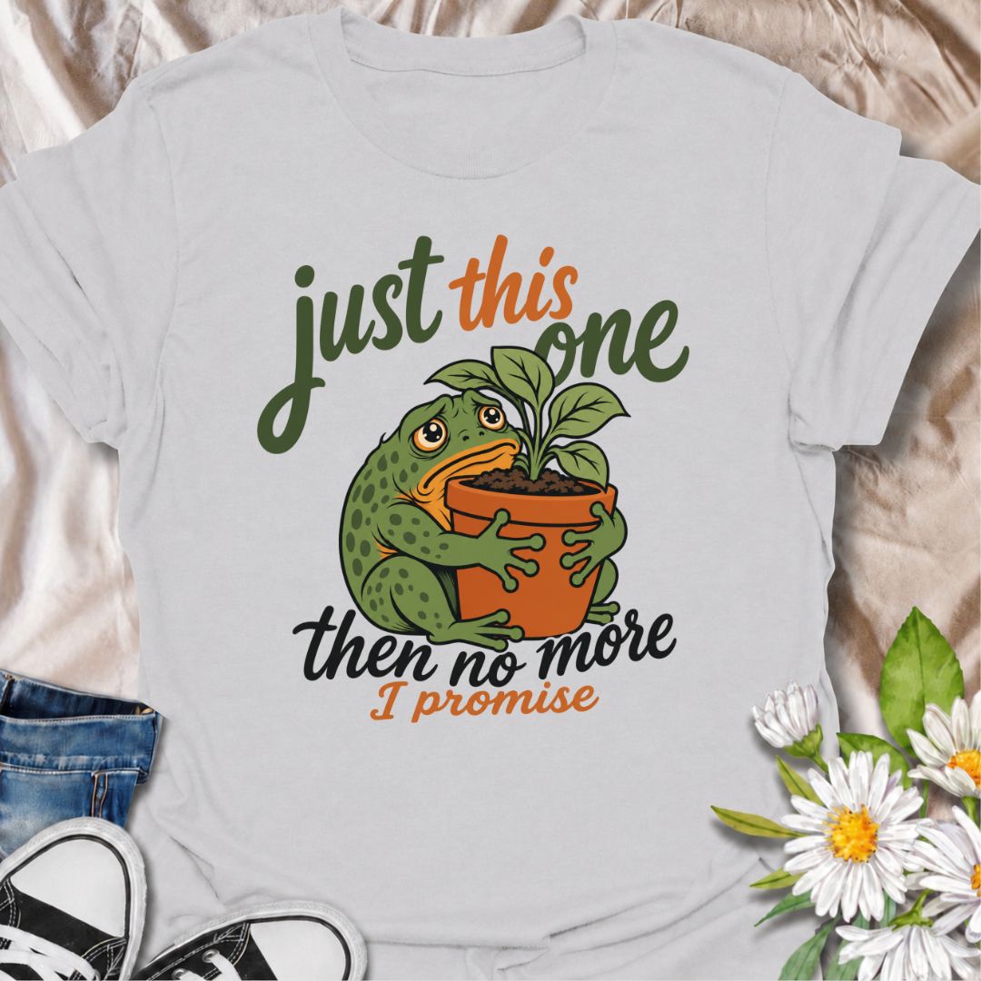 A funny plant T-shirt for anyone who swears every new purchase really will be the last one. The phrase “Just This One, Then No More. I Promise.” pairs with a wide-eyed frog hugging a potted plant for playful, instantly relatable plant-parent humor. It is perfect for houseplant lovers, plant collectors, nursery regulars, and anyone who can never quite resist one more plant. The character-led artwork gives the design plenty of personality while keeping the joke clear and easy to wear. A great gift for plant l