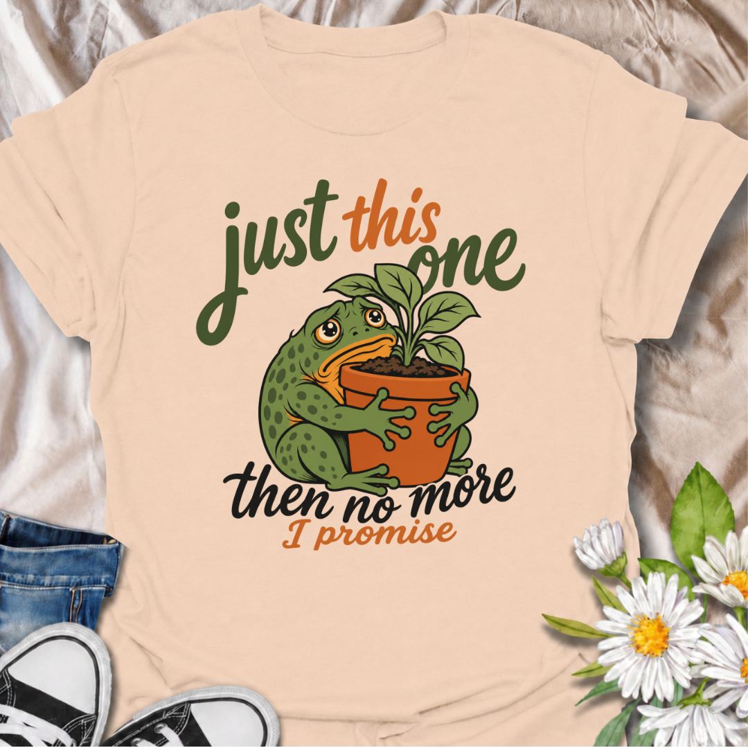 A funny plant T-shirt for anyone who swears every new purchase really will be the last one. The phrase “Just This One, Then No More. I Promise.” pairs with a wide-eyed frog hugging a potted plant for playful, instantly relatable plant-parent humor. It is perfect for houseplant lovers, plant collectors, nursery regulars, and anyone who can never quite resist one more plant. The character-led artwork gives the design plenty of personality while keeping the joke clear and easy to wear. A great gift for plant l