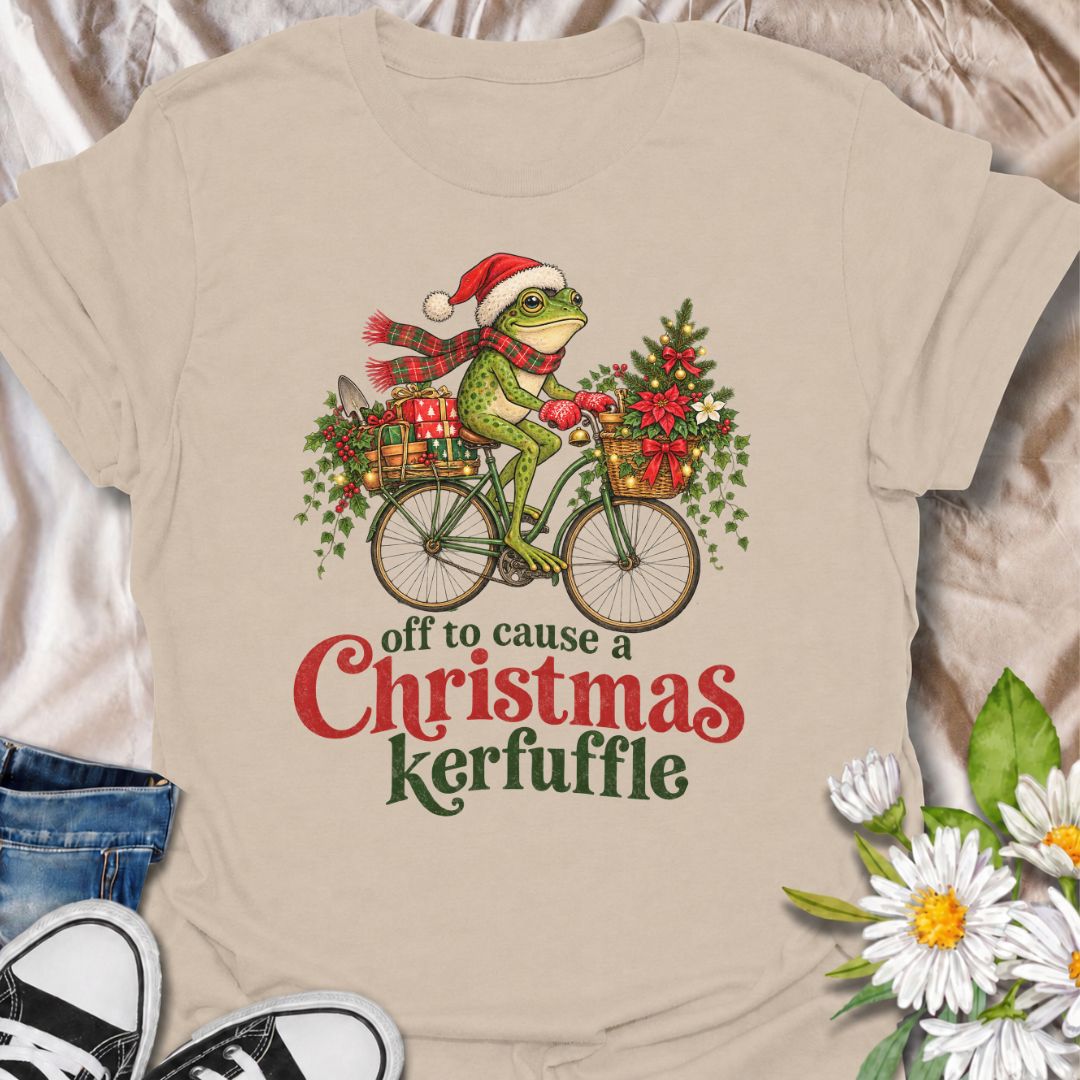 A funny Christmas gardening T-shirt featuring a determined frog cycling off to cause a little festive trouble. The phrase “Off to Cause a Christmas Kerfuffle” combines Botanic Weave’s deadpan frog humor with holly, gifts, garden tools, and plenty of Christmas cheer. It is perfect for gardeners, frog lovers, plant people, and anyone who prefers their holiday shirts funny rather than overly sweet. The detailed vintage-style illustration gives it a festive storybook feel while keeping the joke front and center