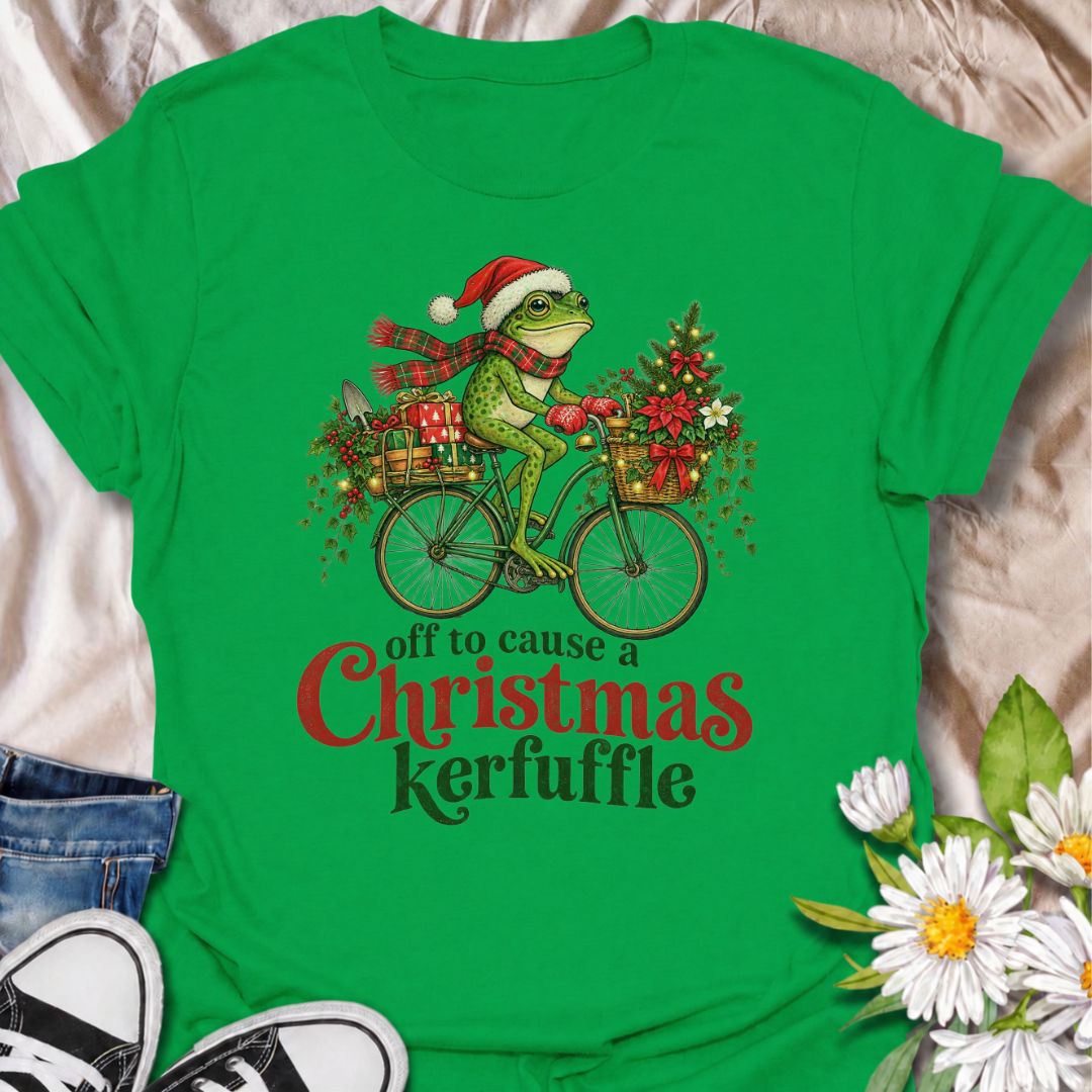 A funny Christmas gardening T-shirt featuring a determined frog cycling off to cause a little festive trouble. The phrase “Off to Cause a Christmas Kerfuffle” combines Botanic Weave’s deadpan frog humor with holly, gifts, garden tools, and plenty of Christmas cheer. It is perfect for gardeners, frog lovers, plant people, and anyone who prefers their holiday shirts funny rather than overly sweet. The detailed vintage-style illustration gives it a festive storybook feel while keeping the joke front and center