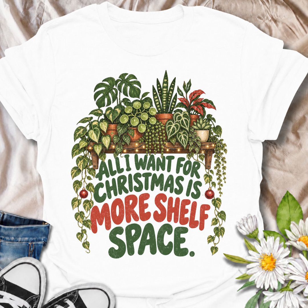 A funny Christmas plant T-shirt for anyone whose real holiday wish is simply more room for houseplants. The phrase “All I Want for Christmas Is More Shelf Space” pairs with a lush plant-filled shelf, trailing vines, fairy lights, and festive ornaments for a design made especially for serious plant collectors. It is perfect for plant parents, houseplant lovers, indoor gardeners, and anyone whose shelves are already overflowing with greenery. The Christmas details make it festive without losing the everyday p