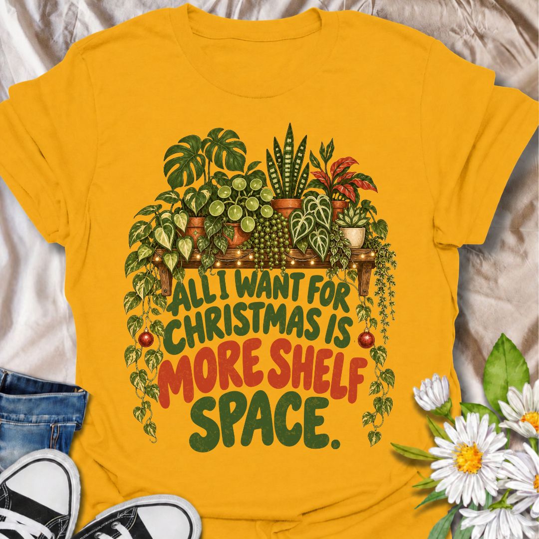 A funny Christmas plant T-shirt for anyone whose real holiday wish is simply more room for houseplants. The phrase “All I Want for Christmas Is More Shelf Space” pairs with a lush plant-filled shelf, trailing vines, fairy lights, and festive ornaments for a design made especially for serious plant collectors. It is perfect for plant parents, houseplant lovers, indoor gardeners, and anyone whose shelves are already overflowing with greenery. The Christmas details make it festive without losing the everyday p