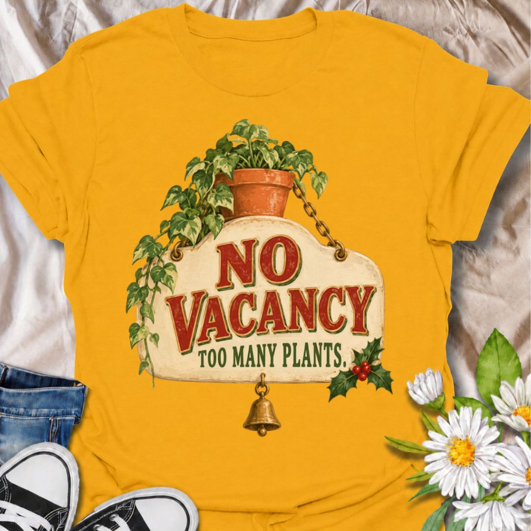 A funny Christmas plant T-shirt for anyone whose home has officially run out of room for more greenery. The phrase “No Vacancy — Too Many Plants” pairs with a vintage hanging sign, trailing houseplant, holly, and a little bell for a festive plant-lover design. It is perfect for houseplant collectors, plant parents, indoor gardeners, and anyone whose shelves and windowsills are already full. The retro sign styling gives it a cozy holiday feel while keeping the joke easy to read. A great Christmas gift for pl