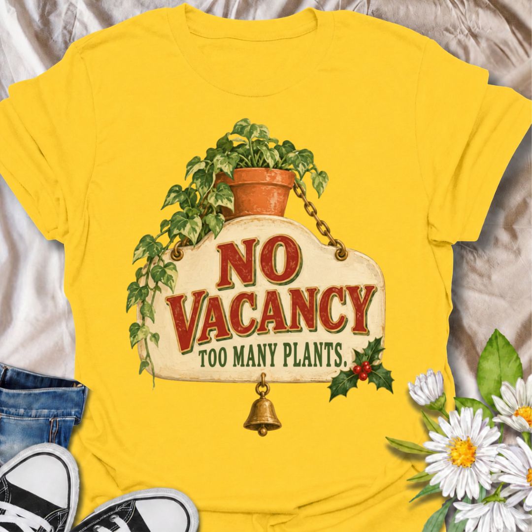 A funny Christmas plant T-shirt for anyone whose home has officially run out of room for more greenery. The phrase “No Vacancy — Too Many Plants” pairs with a vintage hanging sign, trailing houseplant, holly, and a little bell for a festive plant-lover design. It is perfect for houseplant collectors, plant parents, indoor gardeners, and anyone whose shelves and windowsills are already full. The retro sign styling gives it a cozy holiday feel while keeping the joke easy to read. A great Christmas gift for pl