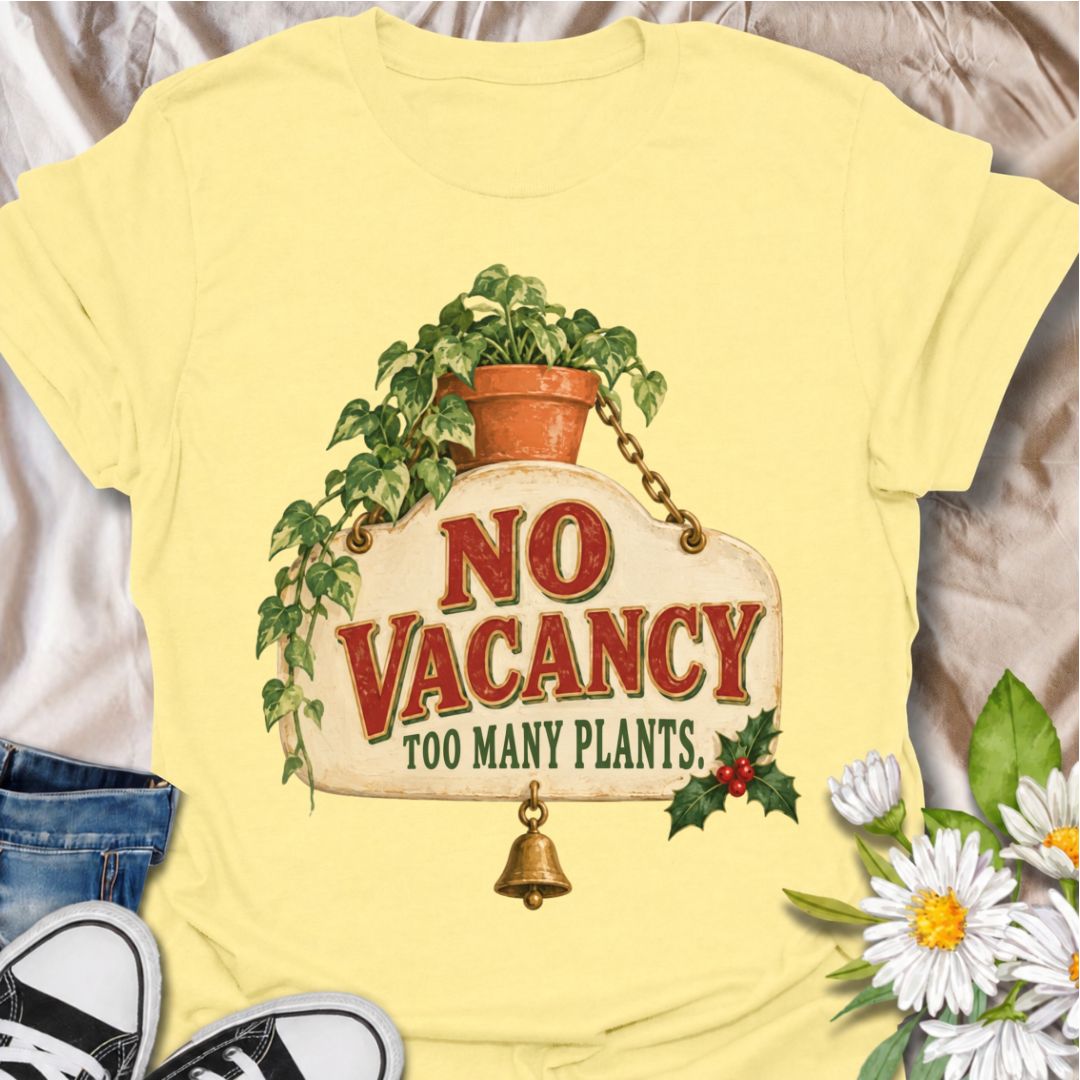 A funny Christmas plant T-shirt for anyone whose home has officially run out of room for more greenery. The phrase “No Vacancy — Too Many Plants” pairs with a vintage hanging sign, trailing houseplant, holly, and a little bell for a festive plant-lover design. It is perfect for houseplant collectors, plant parents, indoor gardeners, and anyone whose shelves and windowsills are already full. The retro sign styling gives it a cozy holiday feel while keeping the joke easy to read. A great Christmas gift for pl