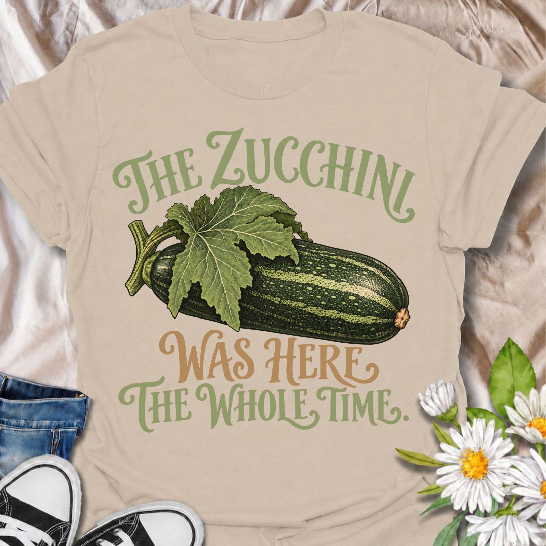 A funny gardening T-shirt for anyone who has ever overlooked a zucchini until it suddenly became enormous. The phrase “The Zucchini Was Here the Whole Time” captures that very specific vegetable-gardener moment with dry, relatable humor. Featuring a large vintage-style zucchini and leafy stem, the design is perfect for backyard gardeners, raised-bed growers, and anyone familiar with surprise harvests. It makes a great gift for vegetable gardeners, zucchini growers, and people who know how quickly squash can