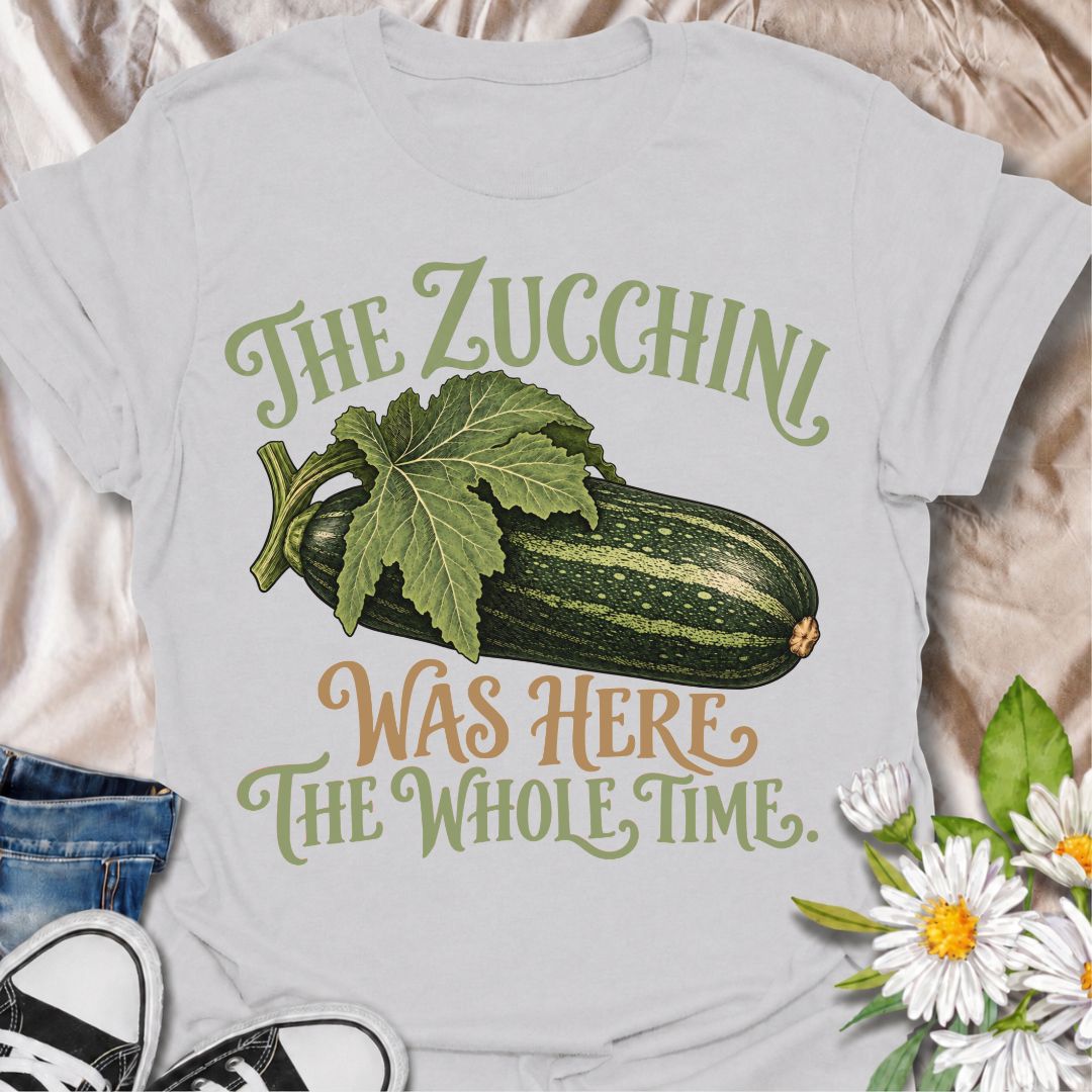A funny gardening T-shirt for anyone who has ever overlooked a zucchini until it suddenly became enormous. The phrase “The Zucchini Was Here the Whole Time” captures that very specific vegetable-gardener moment with dry, relatable humor. Featuring a large vintage-style zucchini and leafy stem, the design is perfect for backyard gardeners, raised-bed growers, and anyone familiar with surprise harvests. It makes a great gift for vegetable gardeners, zucchini growers, and people who know how quickly squash can
