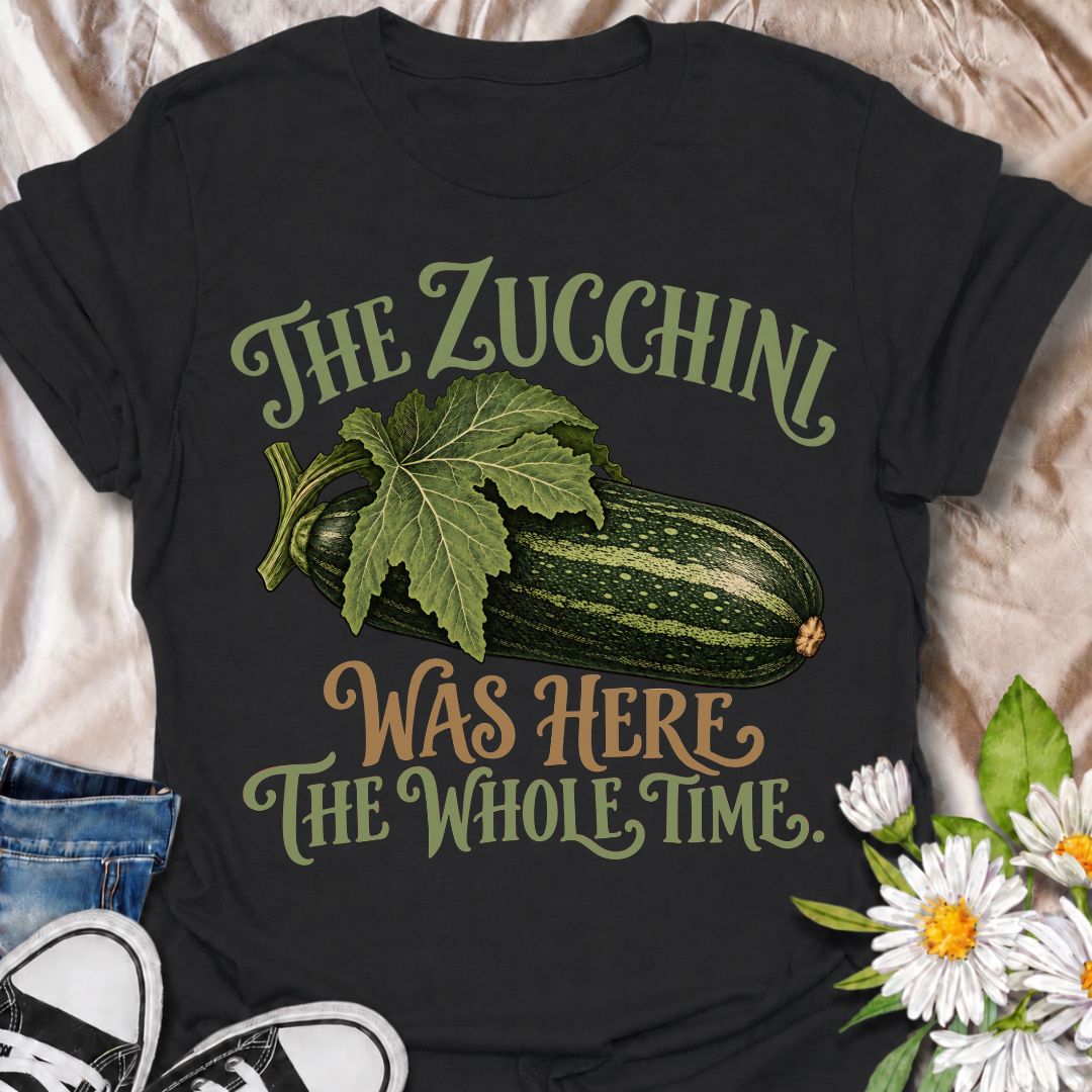 A funny gardening T-shirt for anyone who has ever overlooked a zucchini until it suddenly became enormous. The phrase “The Zucchini Was Here the Whole Time” captures that very specific vegetable-gardener moment with dry, relatable humor. Featuring a large vintage-style zucchini and leafy stem, the design is perfect for backyard gardeners, raised-bed growers, and anyone familiar with surprise harvests. It makes a great gift for vegetable gardeners, zucchini growers, and people who know how quickly squash can