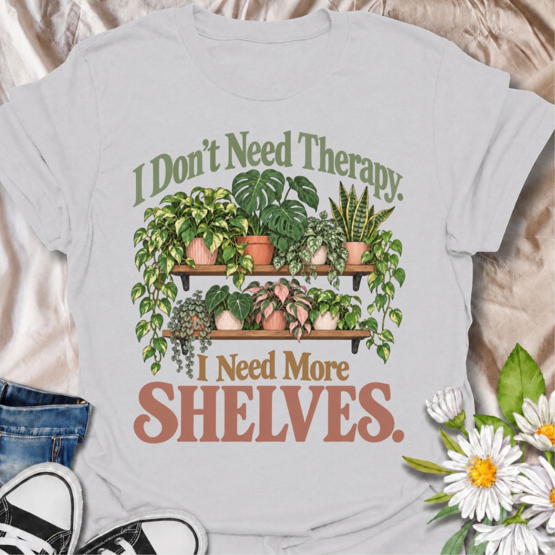 A funny houseplant T-shirt for anyone who has run out of room long before they have run out of plants. The phrase “I Don’t Need Therapy. I Need More Shelves.” pairs with overflowing plant shelves for a relatable houseplant-lover design with plenty of personality. It is perfect for plant parents, indoor gardeners, collectors, and anyone whose windowsills and surfaces are already completely occupied. The lush botanical artwork gives the design a fuller, more decorative look while keeping the joke easy to read