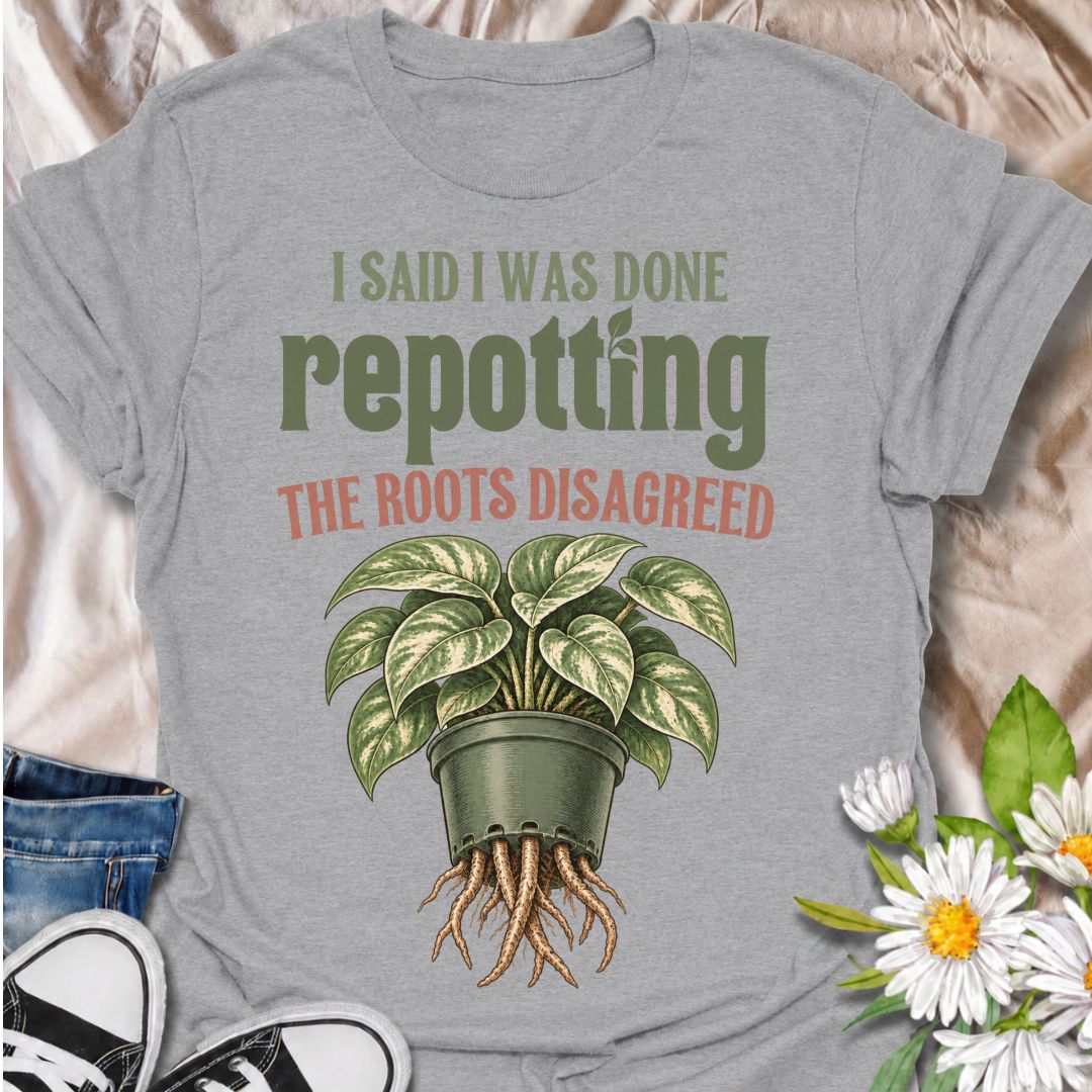 A funny houseplant T-shirt for anyone who thought they were finished repotting until the roots had other ideas. The phrase “I Said I Was Done Repotting. The Roots Disagreed.” captures one of those very familiar plant-parent problems with dry, relatable humor. Featuring a lush potted houseplant with roots pushing through the drainage holes, this design is perfect for indoor gardeners, plant collectors, and anyone constantly upsizing pots. It makes a great gift for pothos lovers, houseplant enthusiasts, and p