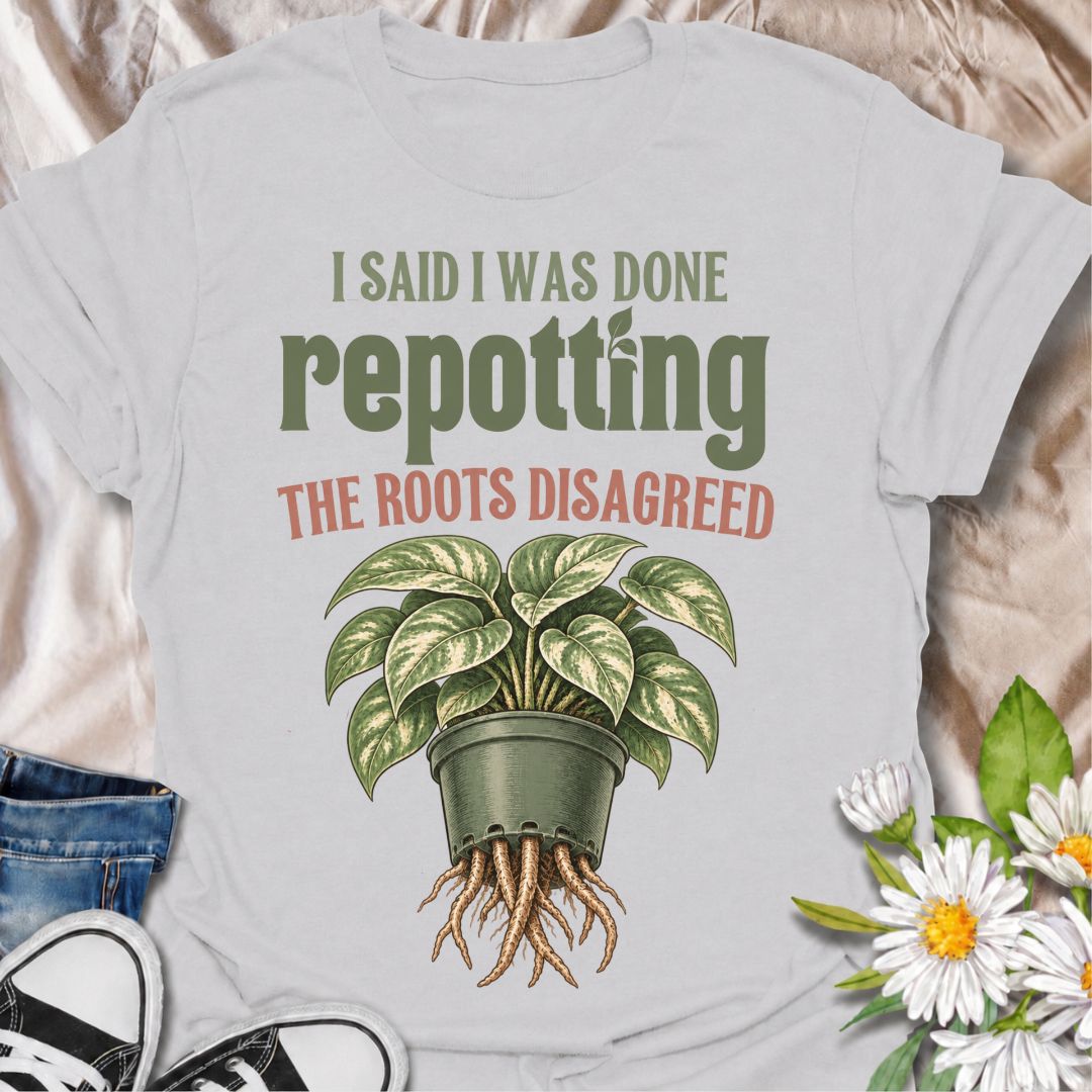 A funny houseplant T-shirt for anyone who thought they were finished repotting until the roots had other ideas. The phrase “I Said I Was Done Repotting. The Roots Disagreed.” captures one of those very familiar plant-parent problems with dry, relatable humor. Featuring a lush potted houseplant with roots pushing through the drainage holes, this design is perfect for indoor gardeners, plant collectors, and anyone constantly upsizing pots. It makes a great gift for pothos lovers, houseplant enthusiasts, and p