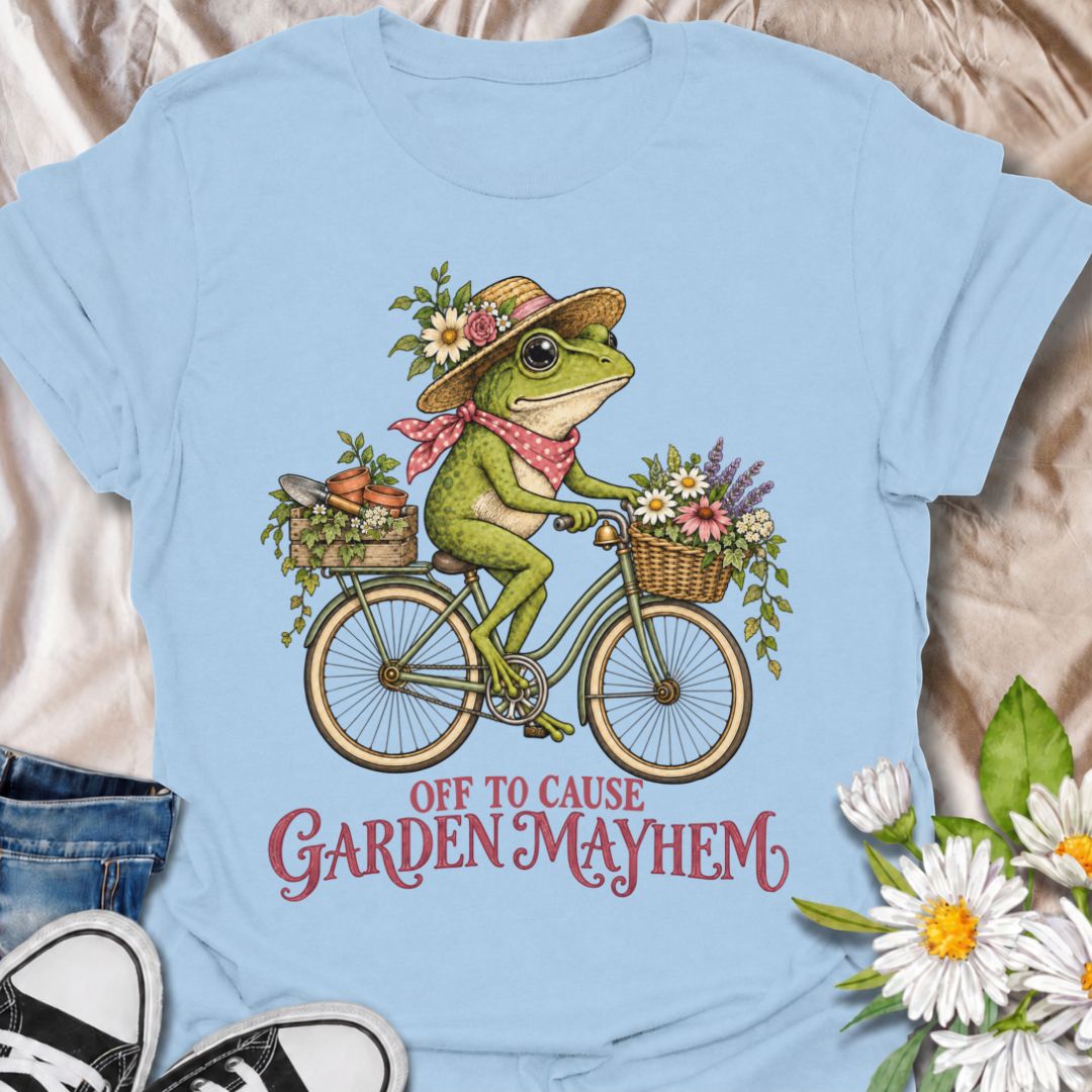 A funny gardening T-shirt for anyone who heads into the garden with good intentions and somehow creates a little chaos along the way. Featuring a cheerful frog riding a bicycle loaded with flowers, pots, and garden supplies, the phrase “Off to Cause Garden Mayhem” gives the design playful, character-led humor. It is perfect for gardeners, flower lovers, frog fans, and anyone who treats a trip around the garden like an adventure. The vintage-style artwork gives it plenty of charm while keeping the joke easy 