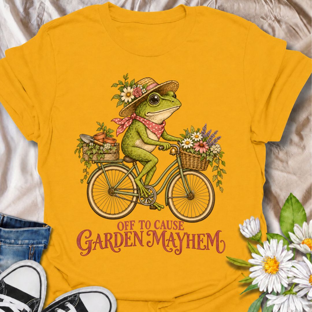 A funny gardening T-shirt for anyone who heads into the garden with good intentions and somehow creates a little chaos along the way. Featuring a cheerful frog riding a bicycle loaded with flowers, pots, and garden supplies, the phrase “Off to Cause Garden Mayhem” gives the design playful, character-led humor. It is perfect for gardeners, flower lovers, frog fans, and anyone who treats a trip around the garden like an adventure. The vintage-style artwork gives it plenty of charm while keeping the joke easy 