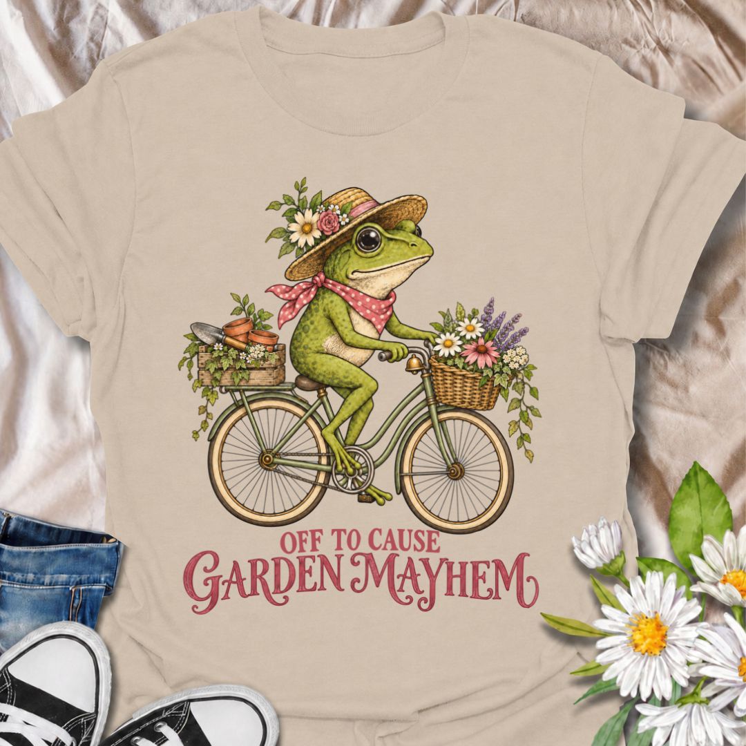 A funny gardening T-shirt for anyone who heads into the garden with good intentions and somehow creates a little chaos along the way. Featuring a cheerful frog riding a bicycle loaded with flowers, pots, and garden supplies, the phrase “Off to Cause Garden Mayhem” gives the design playful, character-led humor. It is perfect for gardeners, flower lovers, frog fans, and anyone who treats a trip around the garden like an adventure. The vintage-style artwork gives it plenty of charm while keeping the joke easy 