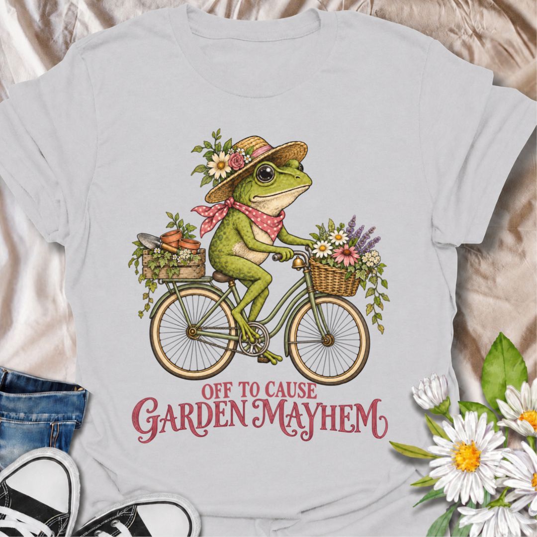 A funny gardening T-shirt for anyone who heads into the garden with good intentions and somehow creates a little chaos along the way. Featuring a cheerful frog riding a bicycle loaded with flowers, pots, and garden supplies, the phrase “Off to Cause Garden Mayhem” gives the design playful, character-led humor. It is perfect for gardeners, flower lovers, frog fans, and anyone who treats a trip around the garden like an adventure. The vintage-style artwork gives it plenty of charm while keeping the joke easy 