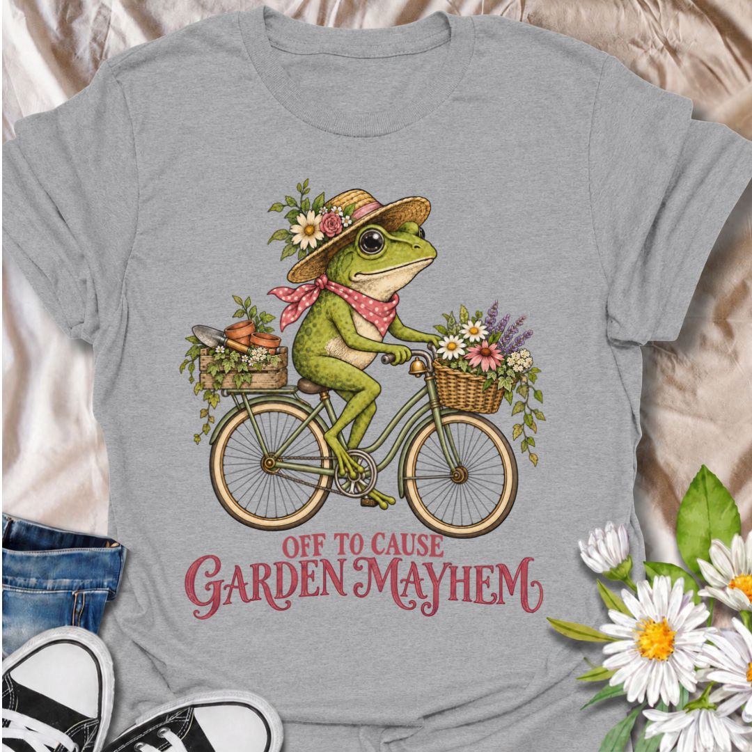 A funny gardening T-shirt for anyone who heads into the garden with good intentions and somehow creates a little chaos along the way. Featuring a cheerful frog riding a bicycle loaded with flowers, pots, and garden supplies, the phrase “Off to Cause Garden Mayhem” gives the design playful, character-led humor. It is perfect for gardeners, flower lovers, frog fans, and anyone who treats a trip around the garden like an adventure. The vintage-style artwork gives it plenty of charm while keeping the joke easy 