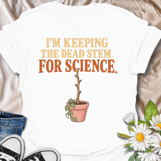 A funny houseplant T-shirt for anyone who keeps a questionable stem around “just in case” there is still some life left in it. The phrase “I’m Keeping the Dead Stem. For Science.” delivers dry, self-aware plant-parent humor that houseplant lovers will instantly understand. Featuring a sad little potted plant with one stubborn dead stem, the design is perfect for indoor gardeners, plant collectors, and anyone who has delayed giving up on a struggling plant. It makes a great gift for plant parents who overthi
