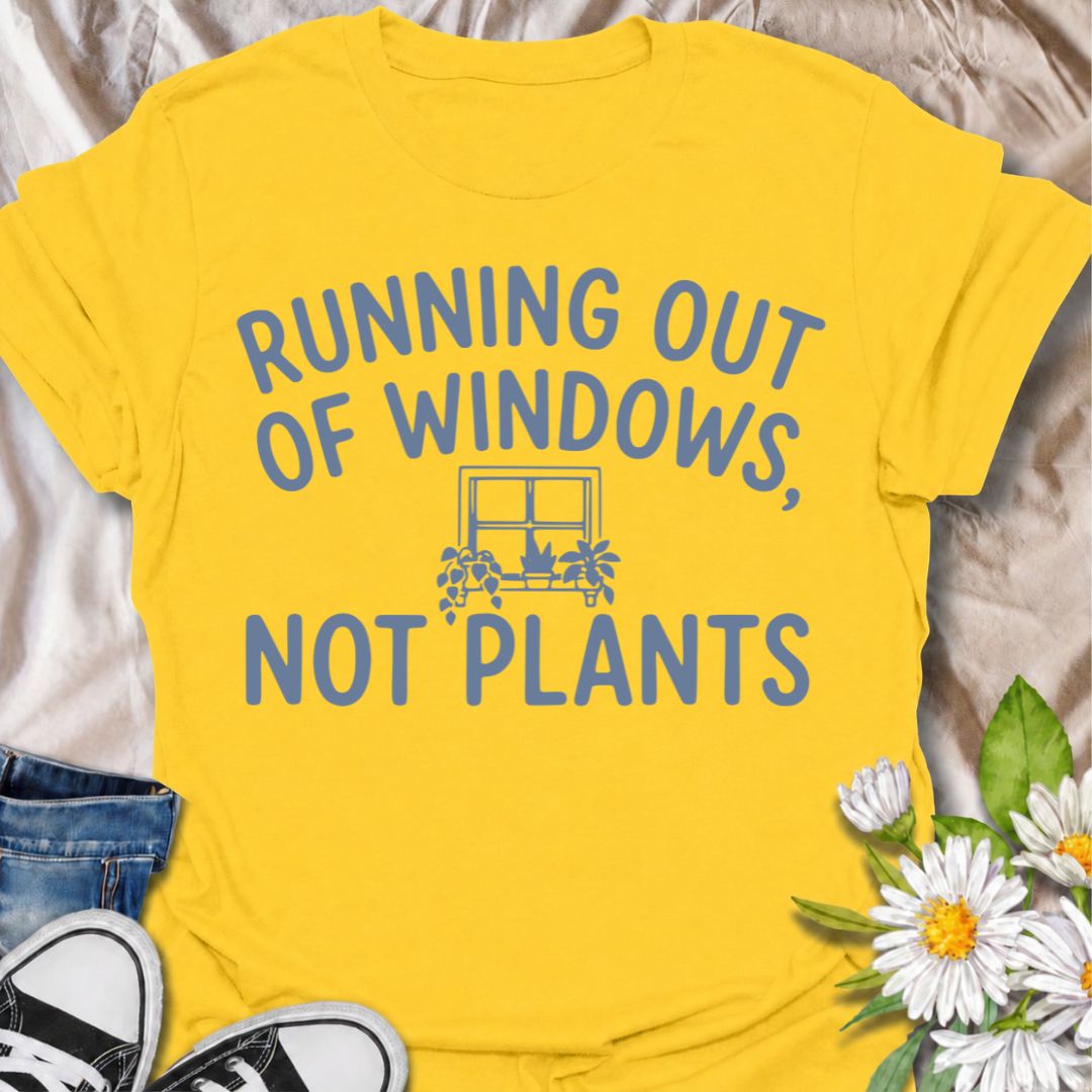 A funny houseplant T-shirt for anyone who is running out of sunny windows long before they are running out of plants. The phrase “Running Out of Windows, Not Plants” captures the reality of an ever-growing indoor jungle with simple, relatable humor. Featuring a small windowsill filled with potted plants, the design is perfect for plant parents, houseplant collectors, and indoor gardeners. It makes a great gift for anyone whose best light has already been claimed by greenery. Perfect for nursery trips, plant