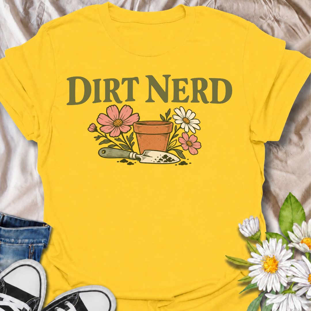 A playful gardening T-shirt for anyone who genuinely gets excited about soil, pots, planting, and everything that goes with growing things. The simple “Dirt Nerd” phrase pairs with flowers, a terracotta pot, and hand trowel for a clean garden-lover design with plenty of personality. It is perfect for backyard gardeners, flower growers, cottage gardeners, and anyone who is happiest with their hands in the soil. The soft vintage-style artwork keeps the design cheerful and easy to wear. A great gift for garden
