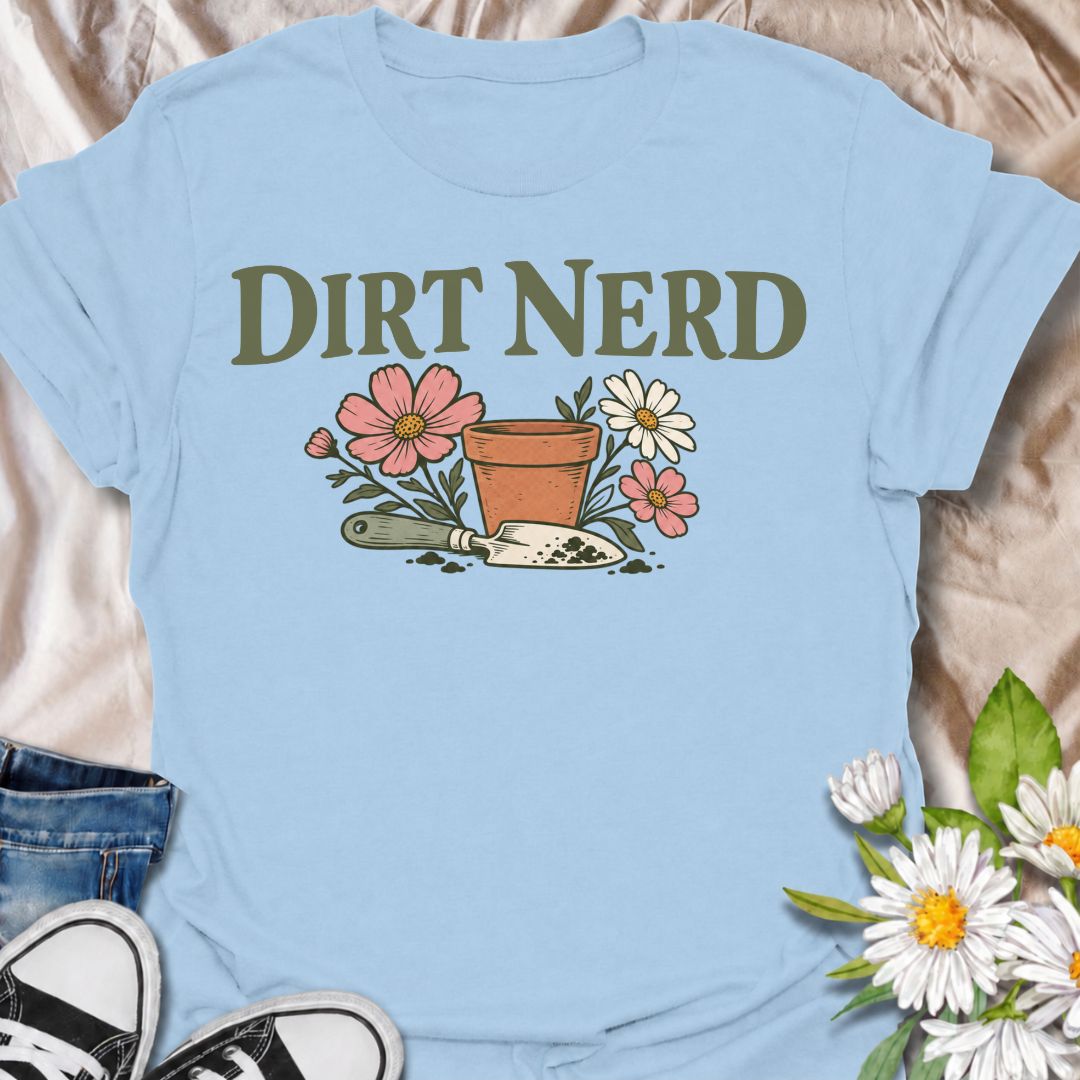 A playful gardening T-shirt for anyone who genuinely gets excited about soil, pots, planting, and everything that goes with growing things. The simple “Dirt Nerd” phrase pairs with flowers, a terracotta pot, and hand trowel for a clean garden-lover design with plenty of personality. It is perfect for backyard gardeners, flower growers, cottage gardeners, and anyone who is happiest with their hands in the soil. The soft vintage-style artwork keeps the design cheerful and easy to wear. A great gift for garden