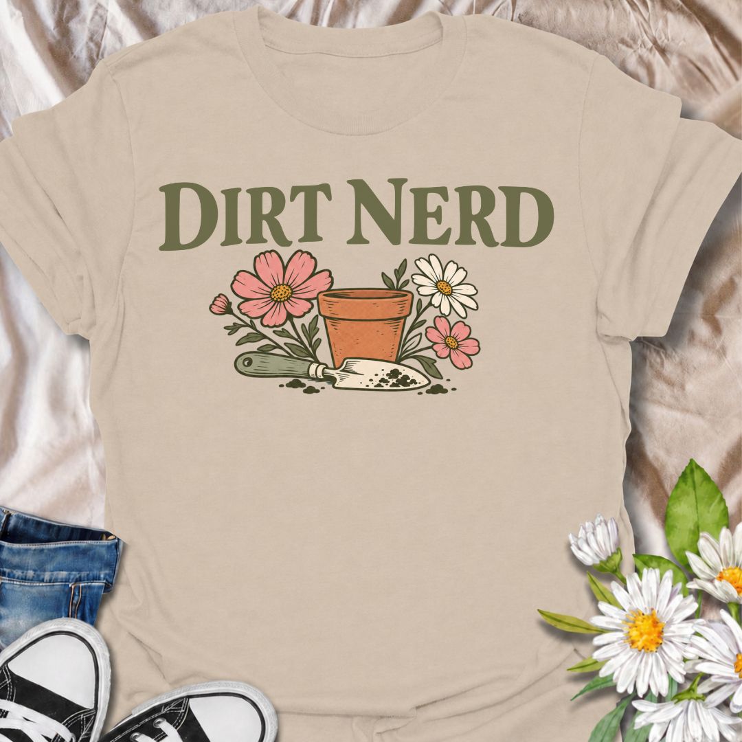 A playful gardening T-shirt for anyone who genuinely gets excited about soil, pots, planting, and everything that goes with growing things. The simple “Dirt Nerd” phrase pairs with flowers, a terracotta pot, and hand trowel for a clean garden-lover design with plenty of personality. It is perfect for backyard gardeners, flower growers, cottage gardeners, and anyone who is happiest with their hands in the soil. The soft vintage-style artwork keeps the design cheerful and easy to wear. A great gift for garden