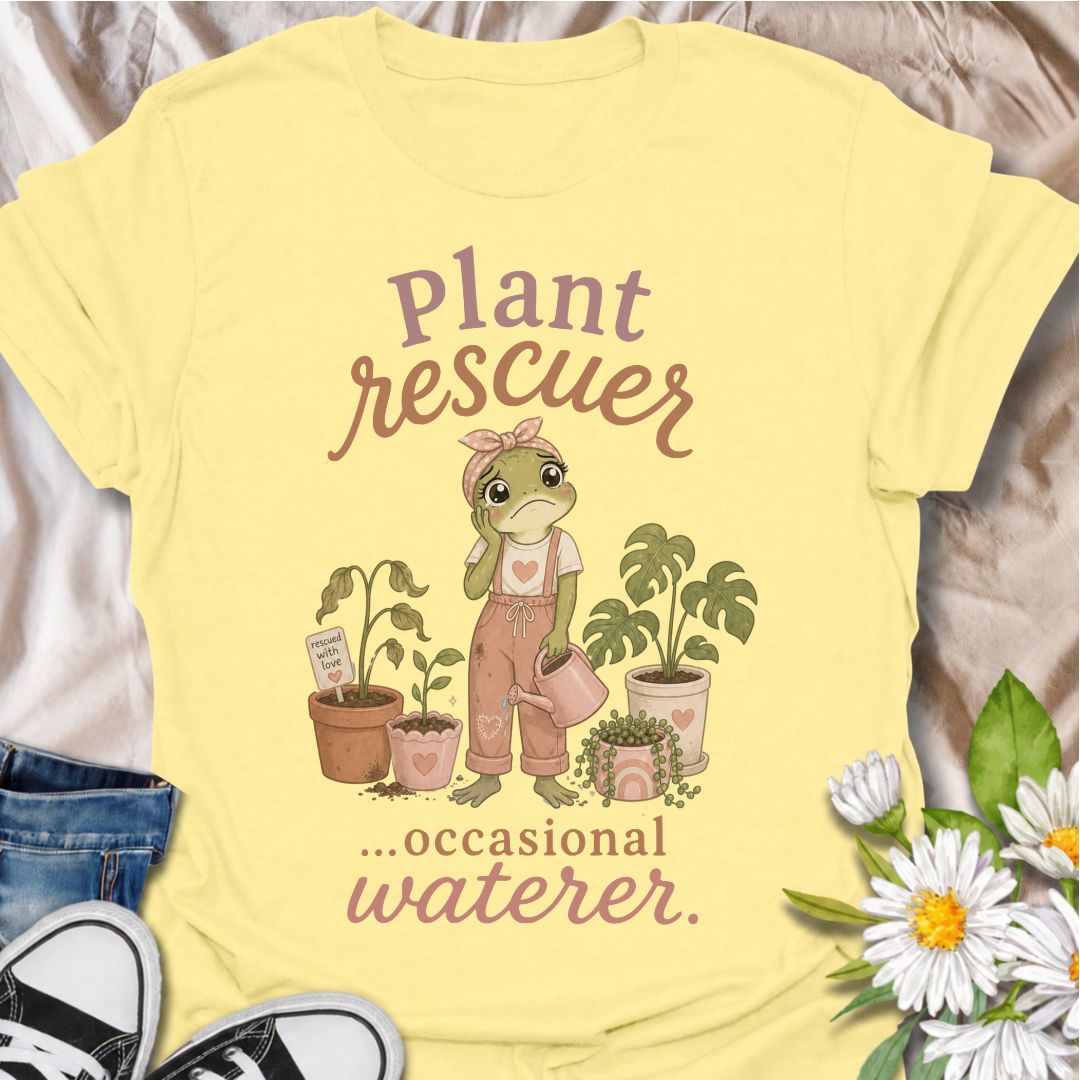 A funny plant T-shirt for anyone who cannot resist trying to save a struggling houseplant. The phrase “Plant Rescuer… Occasional Waterer” pairs with a sweet frog character, wilted plants, watering can, and potted greenery for playful, self-aware plant-parent humor. It is perfect for houseplant lovers, indoor gardeners, and anyone who brings home sad plants with every intention of nursing them back to health. The softer pastel artwork gives the design a warm, feminine feel while keeping the joke clear and re