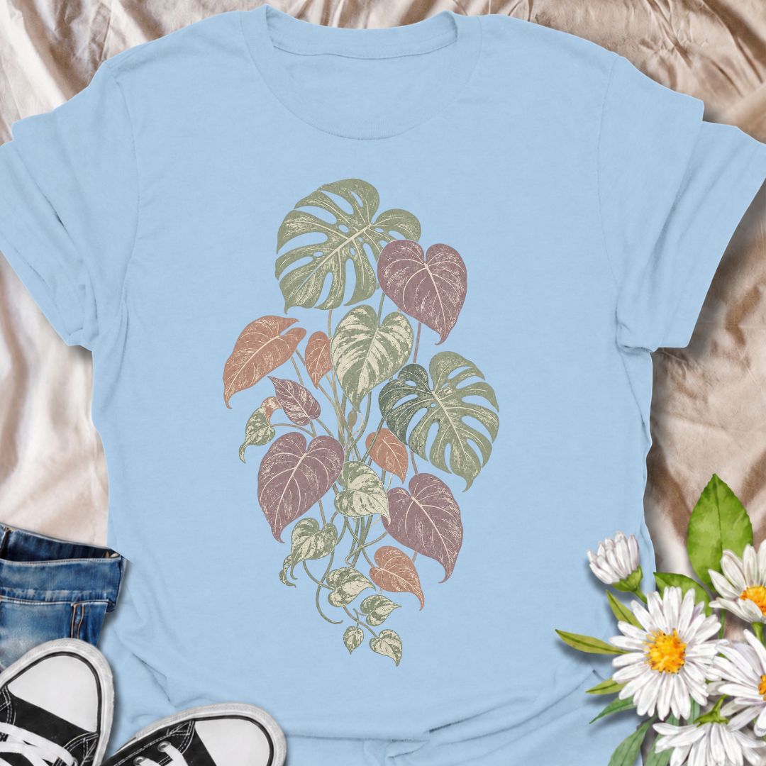 A soft botanical T-shirt for plant lovers who prefer their greenery with a more subtle, feminine feel. Featuring layered monstera, philodendron, and trailing leaves in muted sage, dusty rose, and soft plum tones, this design has an understated vintage look that works beautifully for everyday wear. It is perfect for houseplant lovers, indoor gardeners, botanical enthusiasts, and anyone who enjoys nature-inspired clothing without a slogan. The faded palette gives the artwork a relaxed, slightly worn-in feel w