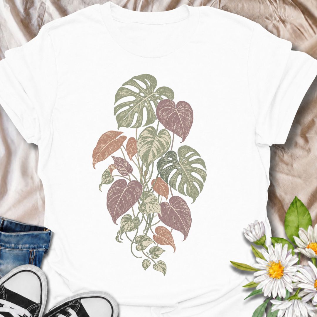 A soft botanical T-shirt for plant lovers who prefer their greenery with a more subtle, feminine feel. Featuring layered monstera, philodendron, and trailing leaves in muted sage, dusty rose, and soft plum tones, this design has an understated vintage look that works beautifully for everyday wear. It is perfect for houseplant lovers, indoor gardeners, botanical enthusiasts, and anyone who enjoys nature-inspired clothing without a slogan. The faded palette gives the artwork a relaxed, slightly worn-in feel w