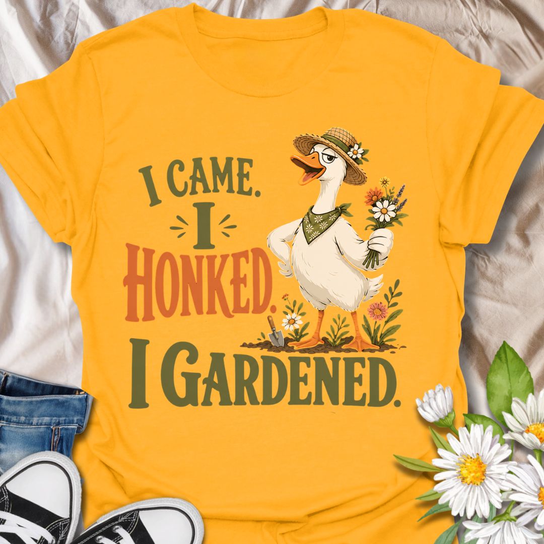 This I Came I Honked I Gardened t-shirt is made for gardeners who like their plant humor with a little chaotic goose energy. Featuring a confident garden goose in a straw hat holding flowers, surrounded by blooms, a trowel, soil, and bold vintage-style lettering, this design has a funny cottagecore garden feel. Perfect for gardeners, plant lovers, flower fans, goose lovers, backyard growers, and anyone who enjoys a playful botanical design with attitude.