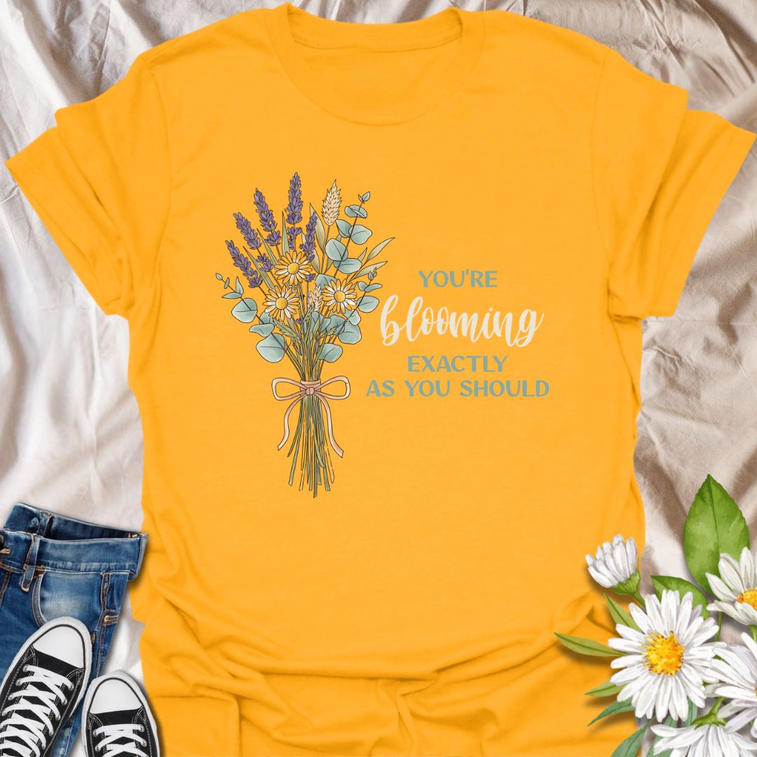 Celebrate growth and self-love with this elegant floral quote t-shirt. Featuring a beautifully illustrated bouquet and the inspiring words "You're blooming exactly as you should", this tee is perfect for anyone on a journey of personal growth. A thoughtful gift for plant lovers, teachers, mental health advocates, or anyone who appreciates uplifting messages in nature-inspired fashion.