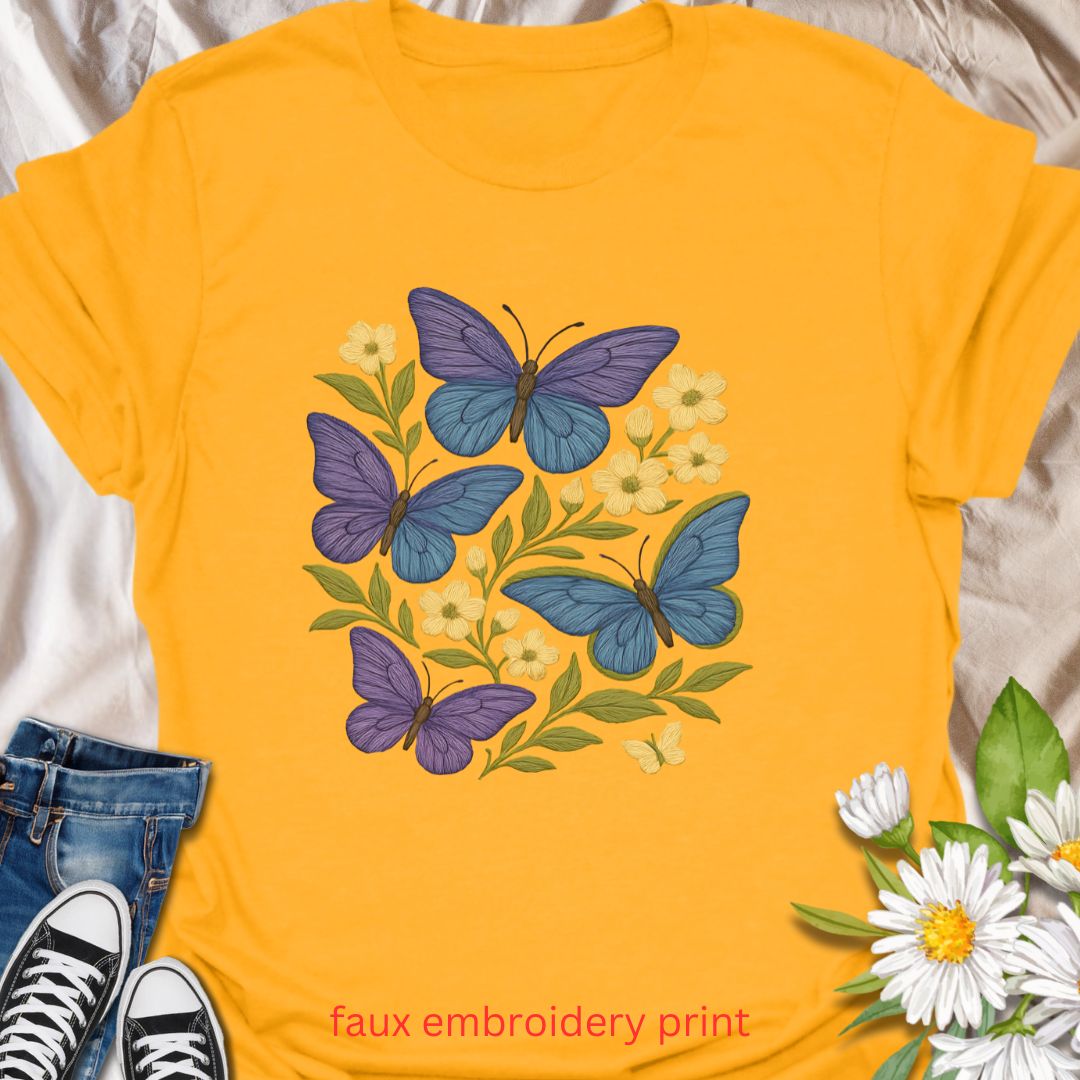Bring whimsical garden vibes to your wardrobe with this faux embroidery butterfly and floral t-shirt. Featuring vibrant blue and purple butterflies among soft yellow flowers, this nature-inspired design mimics stitched embroidery for a cozy, handmade look—without the thread. Perfect for lovers of cottagecore fashion, pollinator gardens, and floral aesthetics.