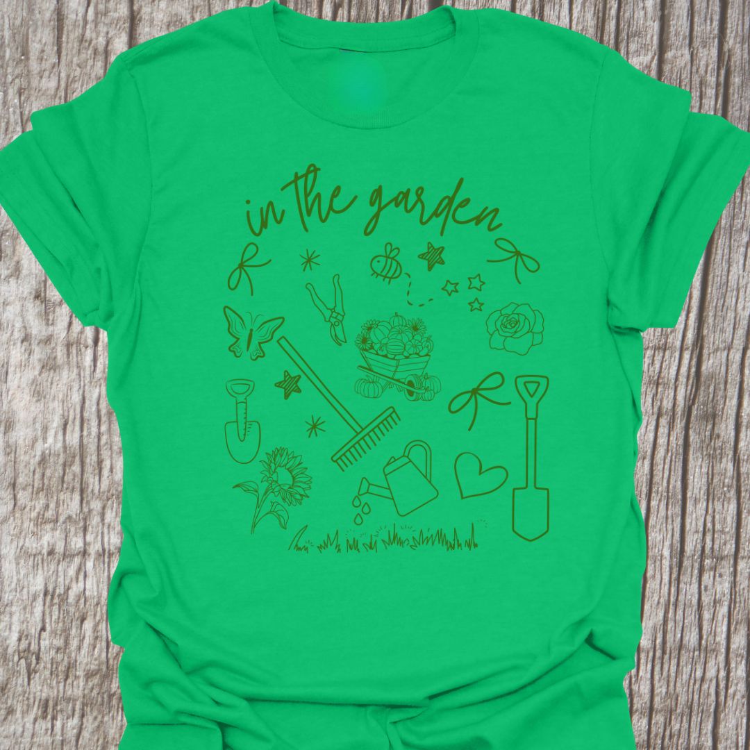Garden Doodle on a T-shirt!  This doodle has garden tools, flowers, grass, bees, butterfly and lots more, green images and text saying 'in the garden'  on an Irish green t-shirt