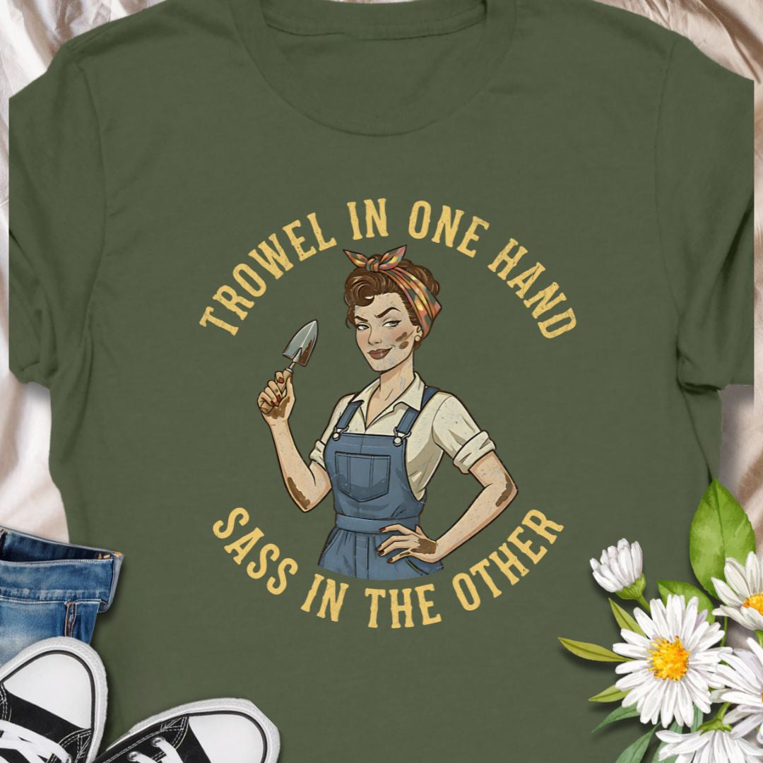 A bold, vintage-inspired gardening t-shirt featuring the phrase “Trowel in One Hand, Sass in the Other.” Perfect for confident gardeners, plant moms, and anyone who loves humor, dirt, and a little attitude in the garden.