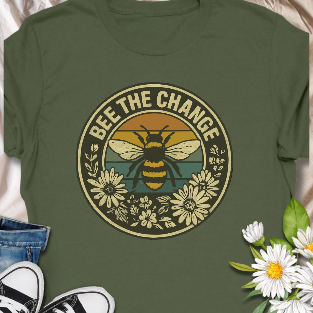 Spread positivity and environmental awareness with this vintage-style “Bee The Change” t-shirt. Featuring a bold bee illustration surrounded by wildflowers and retro sunset colors, it’s perfect for nature lovers, pollinator protectors, and eco-conscious souls. Makes a thoughtful gift for beekeepers, gardeners, or anyone who believes in making a difference—one bee at a time.