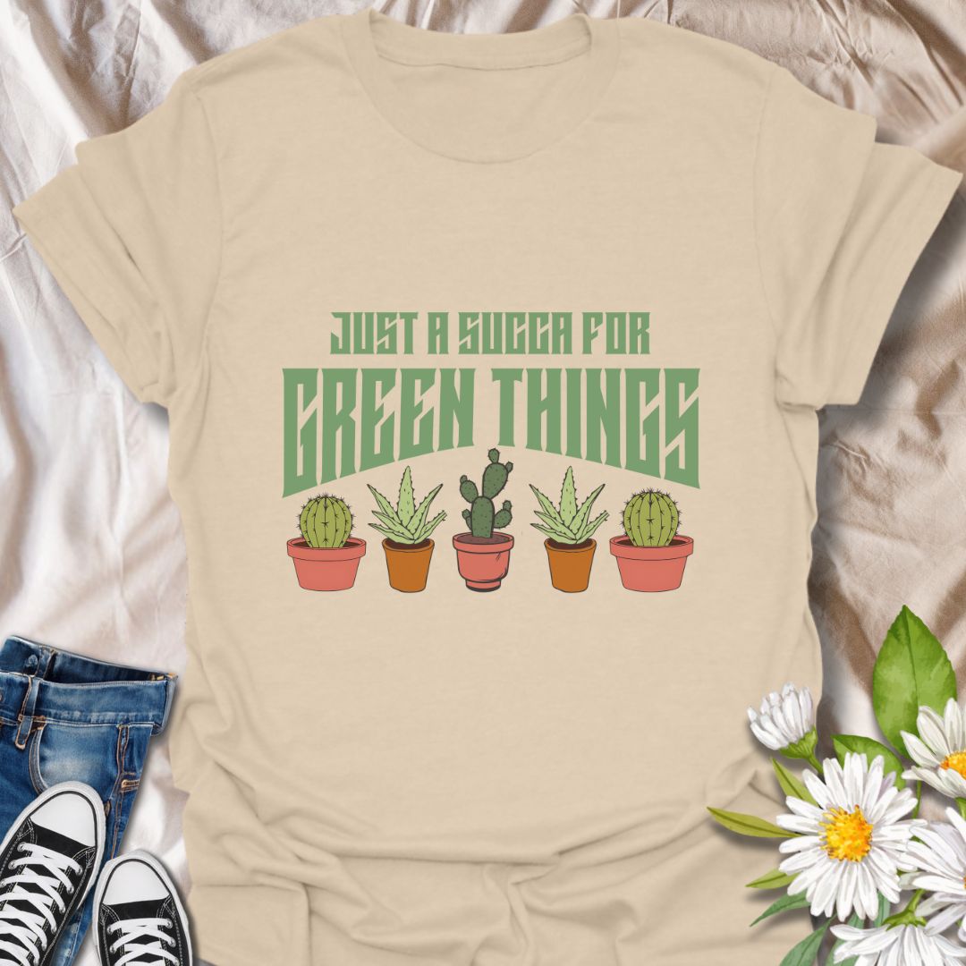 Embrace your love for all things leafy with this playful “Just a Succa for Green Things” t-shirt. Featuring a lineup of adorable potted succulents and bold retro typography, it’s perfect for plant lovers with a sense of humor.