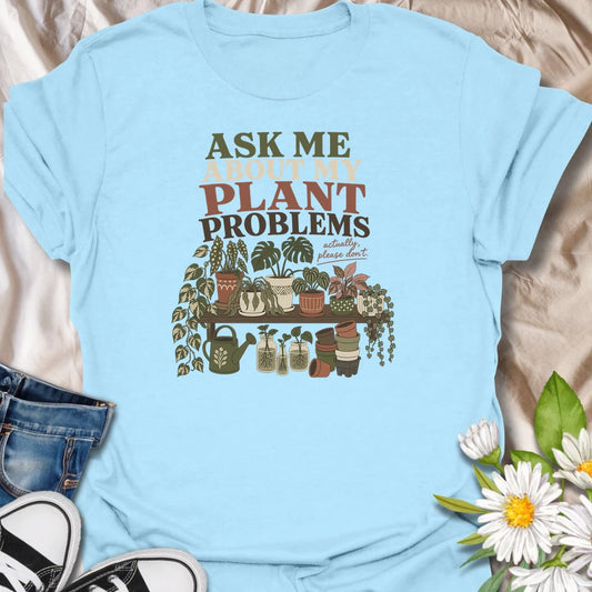Invite a very long conversation with this “Ask Me About My Plant Problems” T-shirt. Featuring a collection of thriving, trailing, and slightly dramatic houseplants, it is ideal for plant parents who always have a care story to share. A funny botanical gift for houseplant collectors and indoor gardeners.