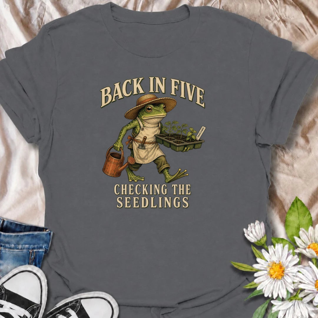 Funny gardening T-shirt for plant lovers who are always disappearing to check seedlings, water pots or inspect the garden. Features a vintage frog gardener illustration and playful “Back in Five, Checking the Seedlings” design for gardeners, growers and houseplant fans.