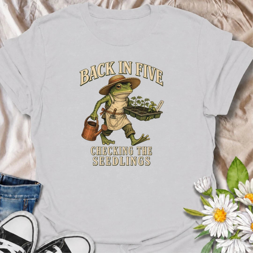 Funny gardening T-shirt for plant lovers who are always disappearing to check seedlings, water pots or inspect the garden. Features a vintage frog gardener illustration and playful “Back in Five, Checking the Seedlings” design for gardeners, growers and houseplant fans.