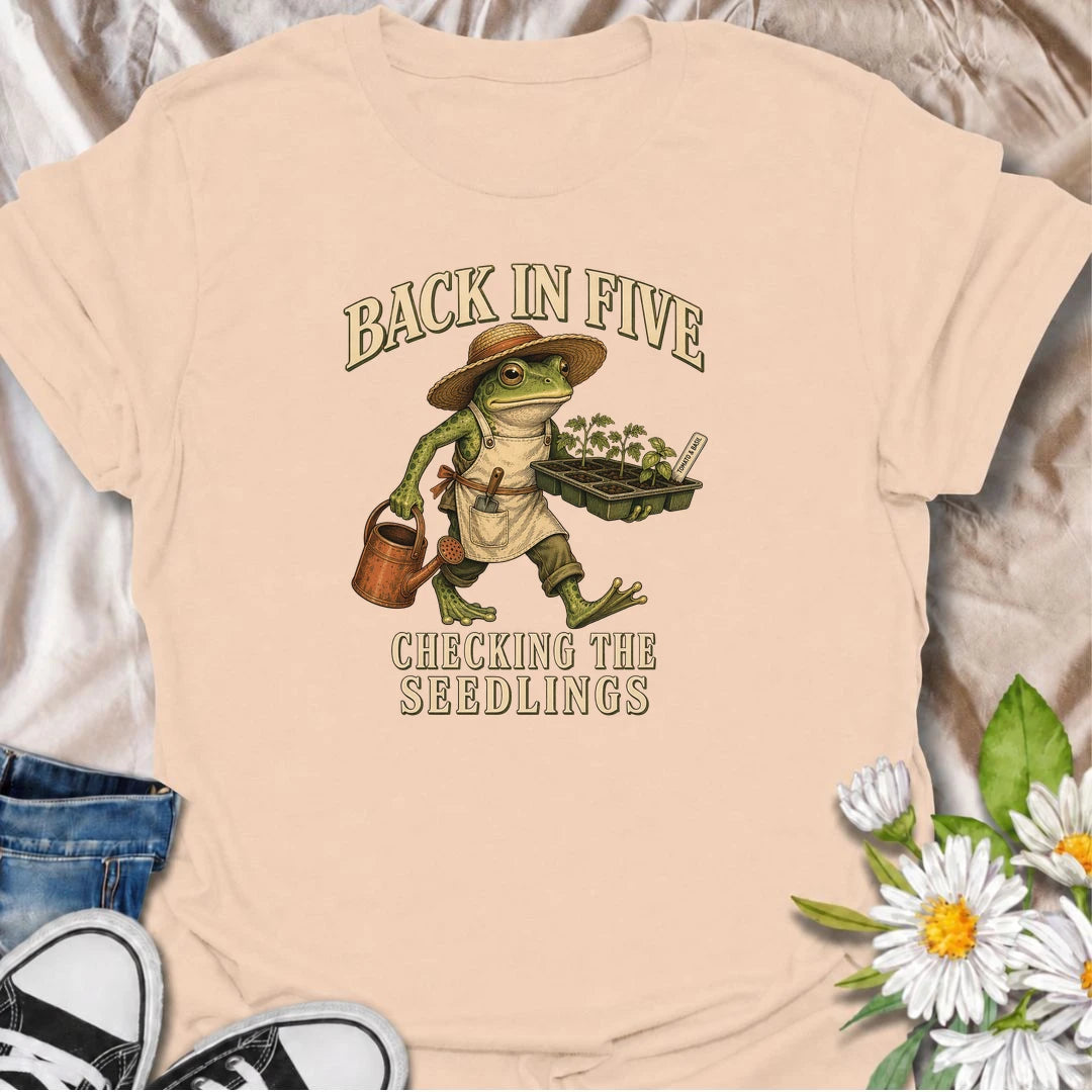 Funny gardening T-shirt for plant lovers who are always disappearing to check seedlings, water pots or inspect the garden. Features a vintage frog gardener illustration and playful “Back in Five, Checking the Seedlings” design for gardeners, growers and houseplant fans.